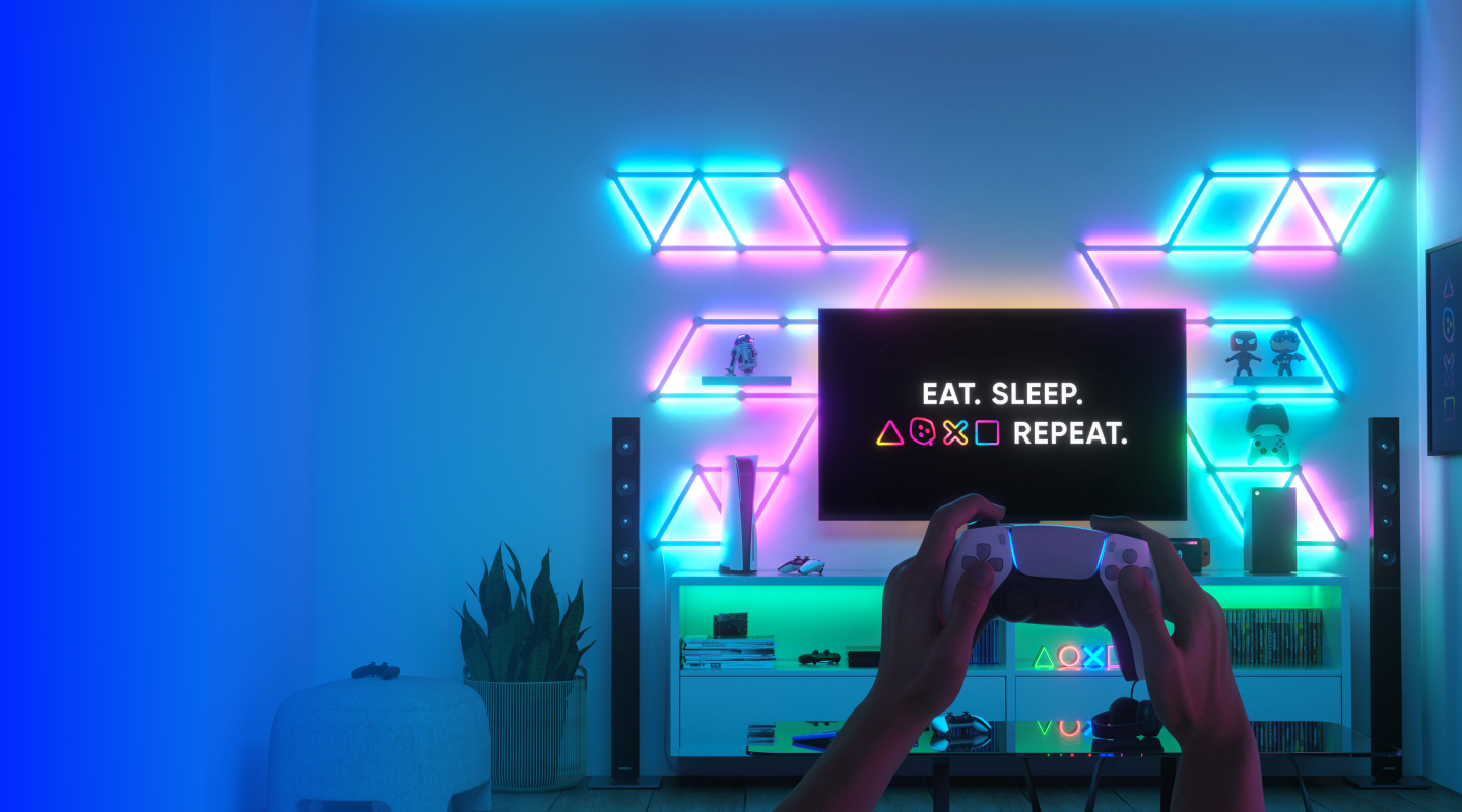 A console gaming room with Nanoleaf Lines RGB lights mounted on both sides of the TV screen. The perfect gaming lights for console games.