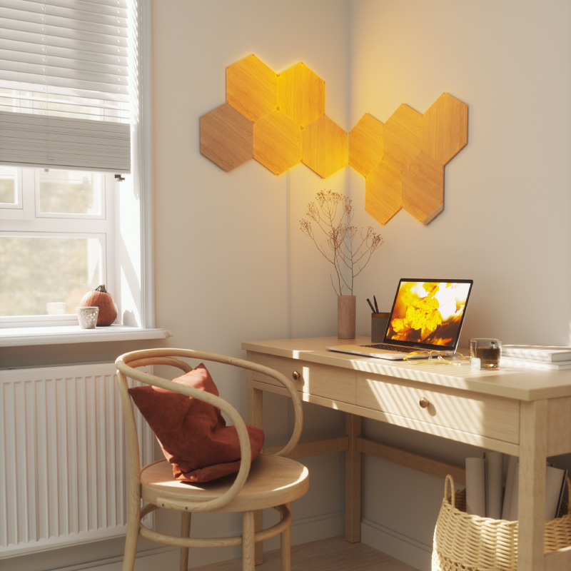 Nanoleaf Elements Thread-enabled wood-look hexagon smart modular light panels flex linkers mounted to a wall in a home office. HomeKit, Google Assistant, Amazon Alexa, IFTTT. 