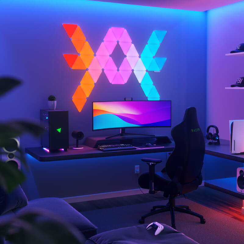 Nanoleaf Shapes Thread-enabled color-changing triangle smart modular light panels mounted to a wall above a battlestation. Similar to Philips Hue, Lifx. HomeKit, Google Assistant, Amazon Alexa, IFTTT.